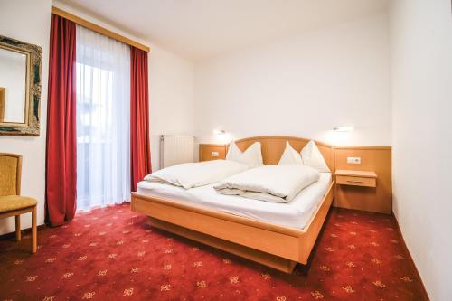 - une chambre avec un lit et un tapis rouge dans l'établissement Landhaus Gretl by S4Y, à Krumpendorf am Wörthersee