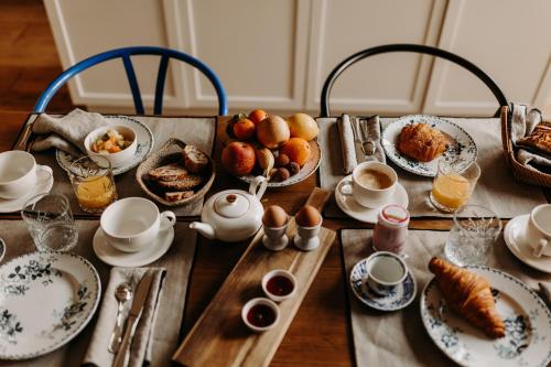 una mesa cubierta con platos y tazas de café y comida en B&B Maison Rosa en Burdeos