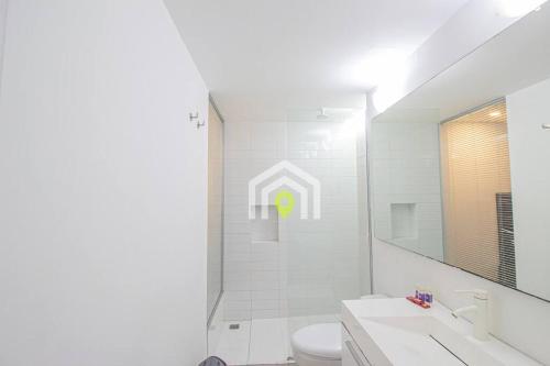 ein Badezimmer mit einem WC, einem Waschbecken und einem Spiegel in der Unterkunft Avenida el poblado La frontera con terraza in Medellín