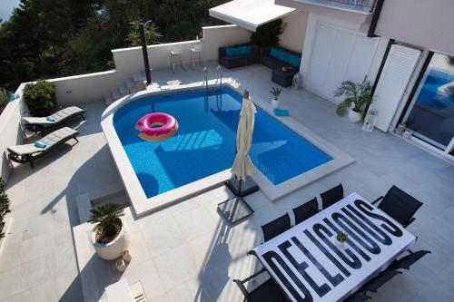 バシュカ・ヴォダにあるLuxury Villa Rogacの傘付きのスイミングプールのオーバーヘッドビュー