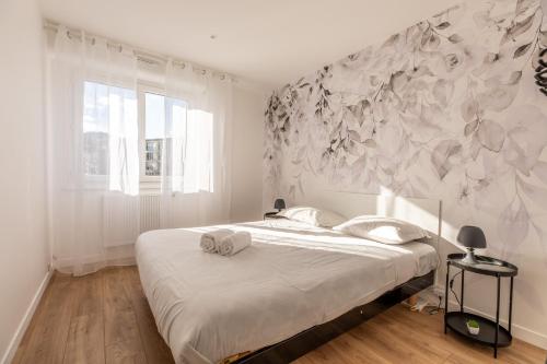 1 dormitorio con 1 cama con pared de flores en Magnifique F3 *Galaxy* tout équipé, en Clermont-Ferrand