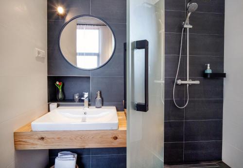 een badkamer met een wastafel en een spiegel bij Erkan Alek Heritage Hotel in Gjoemri