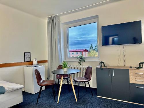 een hotelkamer met een tafel en stoelen en een raam bij Morava 305 Uherské Hradiště Šafaříkova 855 in Uherské Hradiště