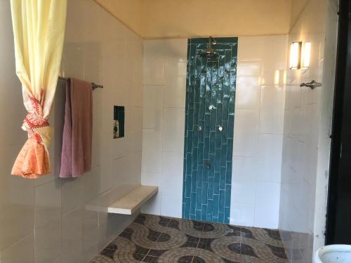 a shower with a glass door in a bathroom at Casita Amarilla in the Yellow City in Izamal