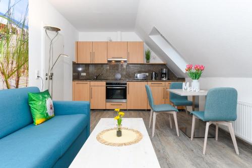 a living room with a blue couch and a table at Haus Strandkorb mit Frühstücksoption in Bensersiel