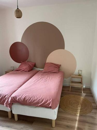 - une chambre avec un lit et une couette rose dans l'établissement Le Bubble, à Épernay