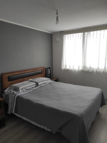 a bedroom with a bed and a window at Depto in Temuco