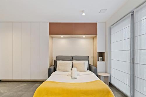 a bedroom with a large bed with a yellow blanket at Classy Studio near to Cloche d'Or in Luxembourg
