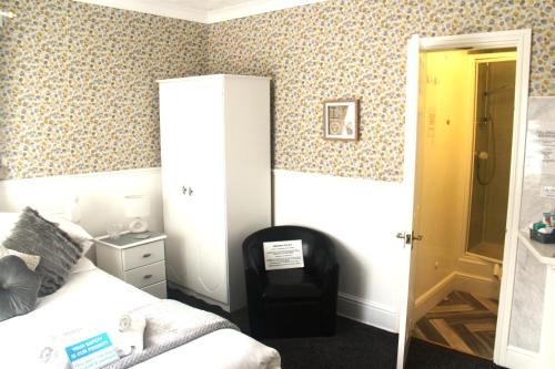 a bedroom with a bed and a chair at Serena Court Hotel in Skegness