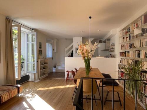 un salon avec un vase de fleurs sur une table dans l'établissement Magnifique maison 15 minutes du centre historique de Paris, aux Lilas