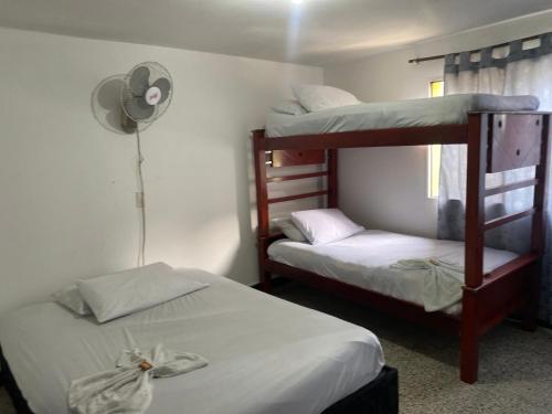 Una habitación con dos literas y un ventilador. en Hotel Estadio Suite, en Medellín