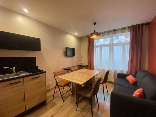 een keuken en een woonkamer met een tafel en een bank bij Le nid du Quai by Concierge City in Lille