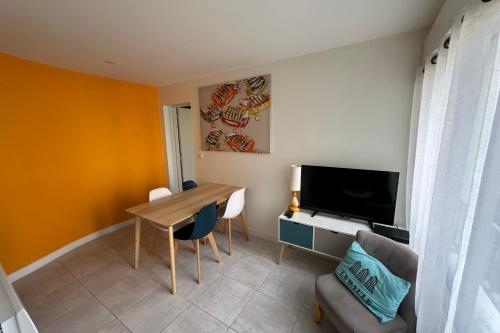 Elle comprend un petit salon avec une table et une télévision. dans l'établissement Love cocoon close to the sea in La Baule-Escoublac, à La Baule