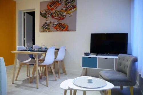 een woonkamer met een tafel en een televisie bij Love cocoon close to the sea in La Baule-Escoublac in La Baule