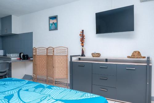 um quarto com uma cama e uma televisão na parede em Grey Studio Papeete - Perfect Transit or Short Stay em Papeete