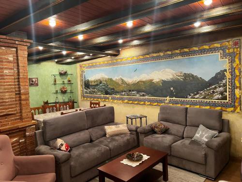 a living room with a couch and a painting on the wall at CASA PELENTOS Sandinies in Sandiniés