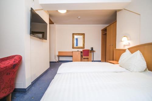a hotel room with two beds and a desk at Landhaus Gretl by S4Y in Krumpendorf am Wörthersee