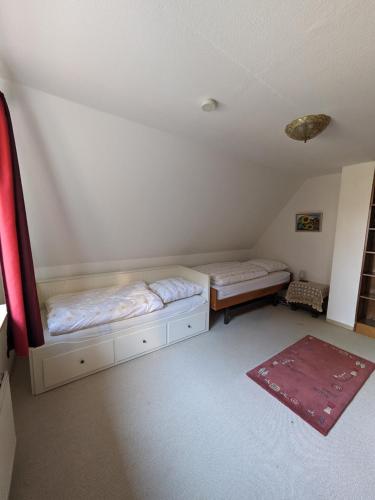 Zimmer im Dachgeschoss mit 2 Betten und einem Teppich in der Unterkunft Ferienwohnung Blumenweg in Büchen