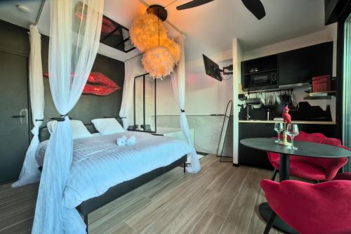 une chambre avec un lit et une table avec des chaises dans l'établissement Le balcon romantique, à Metz