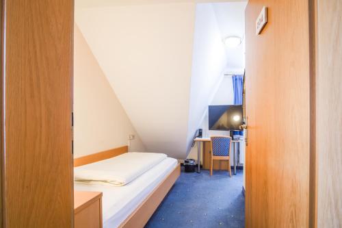 - une petite chambre avec un lit et un bureau dans l'établissement Landhaus Gretl by S4Y, à Krumpendorf am Wörthersee