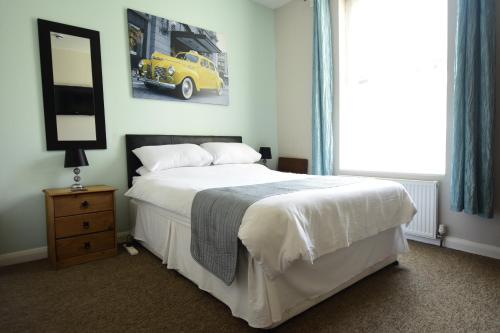 a bedroom with a bed with a yellow car on the wall at Grosvenor Guest House in Hastings