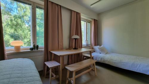 ラハティにあるEnjoyNature B&Bのベッドルーム1室(ベッド1台、デスク、ベッド1台、窓付)