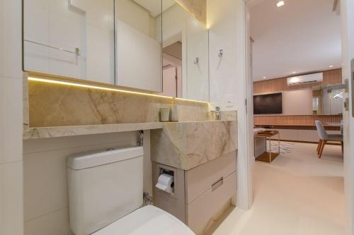 uma casa de banho com um lavatório e um WC num quarto em Apto Alto Luxo no Pátio Milano em Florianópolis