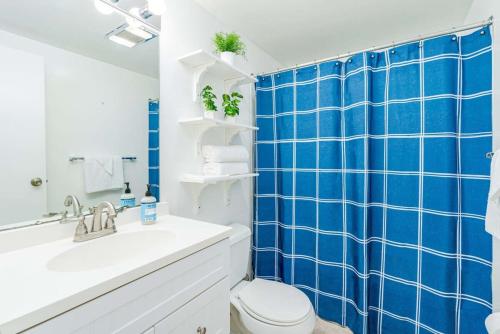 a blue tiled bathroom with a toilet and a sink at Cabin w Hot Tub, Huge Deck, Firepit & WiFi! in Hedgesville