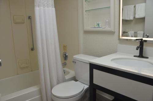 a white bathroom with a toilet and a sink at Quality Inn in Perrysburg