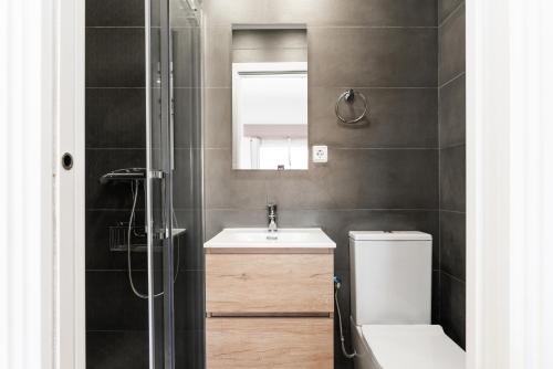 a bathroom with a sink and a toilet and a mirror at La Sagrera House in Barcelona