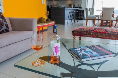 a bottle of wine and a glass on a glass table at Villa Azul Apartment in Quito