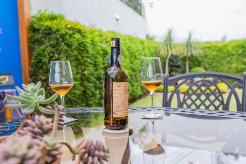 a bottle of wine sitting on a table with two wine glasses at Villa Azul Apartment in Quito