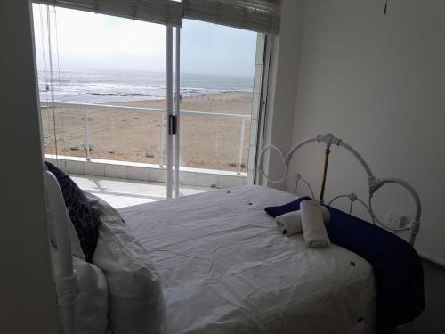 a bedroom with a bed with a view of the beach at Camere da Letto ON-THE-BEACH Self Catering in Swakopmund