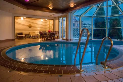 a large swimming pool in a house with a patio at Clarion Collection Hotel Smedjan in Sandviken