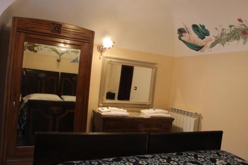 La Dimora di Ziella في Barisciano: غرفة نوم مع مرآة وسرير وخزانة