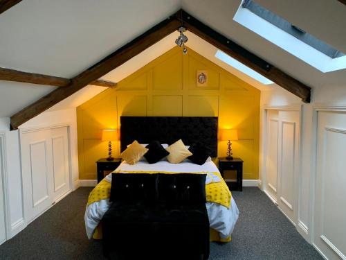 sypialnia z dużym łóżkiem z żółtymi ścianami w obiekcie The Wizard's Loft w mieście Alnwick