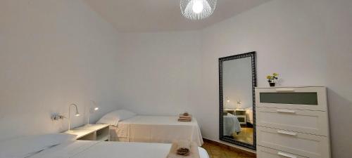 a white room with a bed and a mirror at 10 km From Airport in Vecindario