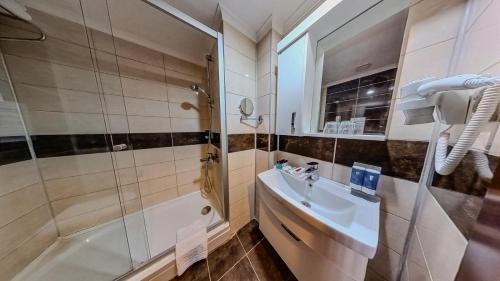 uma casa de banho com um chuveiro, um lavatório e uma banheira em Adella Side Hotel em Side