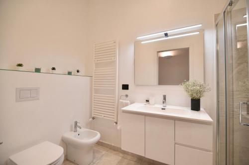 een witte badkamer met een toilet en een wastafel bij San Niccolò Luxury Apartment in Florence