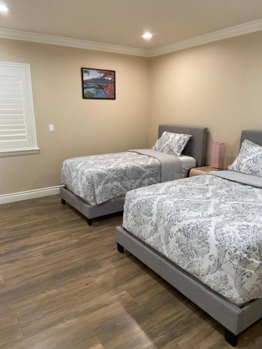 a bedroom with two beds and a window at New! Cozy Gated 3BR, 2BA Vacation Home in Rosemead