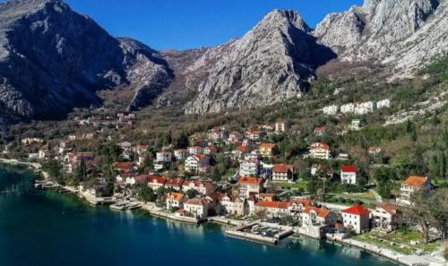 a small town on the shore of a lake with mountains at Sea side apartment in Kotor