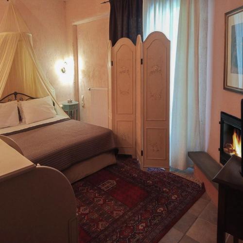 a bedroom with a bed and a fireplace at Αρχοντικό Άννα Μαρία - Βουργαρέλι Τζουμέρκα in Vourgareli