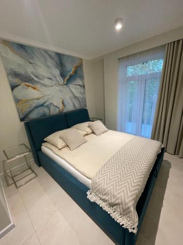 um quarto com uma cama com um quadro na parede em Copernicus Sky Apartment em Zielona Góra