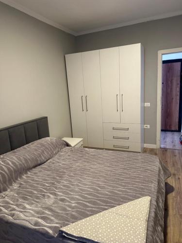 a bedroom with a bed and white cabinets at Luxury apartment in the calmest area in Tirana