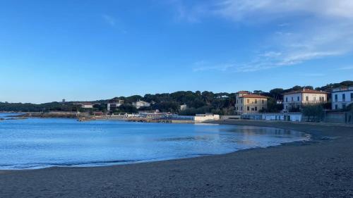 a view of a beach with houses and the water at A due passi dal mare in Castiglioncello
