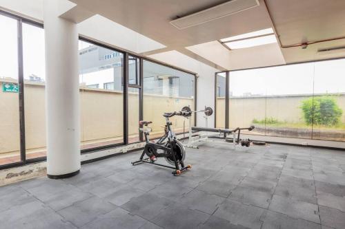 a gym with a exercise bike in a room with large windows at Akros Galapagos Suite in Quito