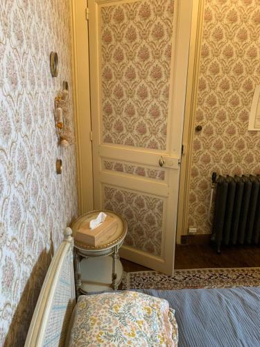Cette chambre dispose d'une porte et d'un tabouret à côté d'un lit. dans l'établissement Château de la Franceule - la petite, à Janzé