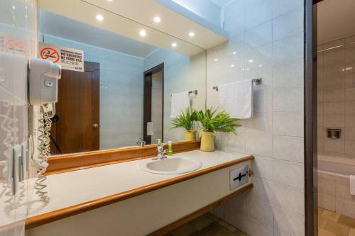 a bathroom with a sink and a mirror at Akros Galapagos Suite in Quito