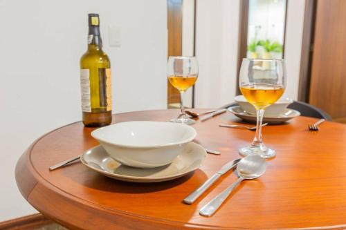 a wooden table with two glasses of wine and a bowl at Akros Galapagos Suite in Quito