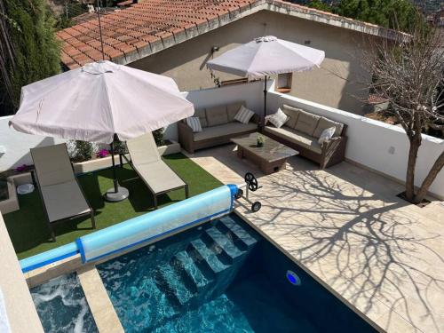 basen z parasolem i krzesłami oraz kanapą w obiekcie Lux@Spa2 w mieście Vallirana